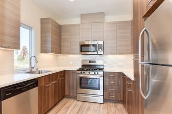 Kitchen with Hardwood Inspired Floors, Stainless Steel Fridge/Freezer. Dishwasher, Oven, Microwave at Addison Ranch Apartments, California